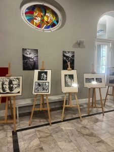 Fotografie na sztalugach we foyer teatru.