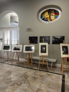 Fotografie na sztalugach we foyer teatru.
