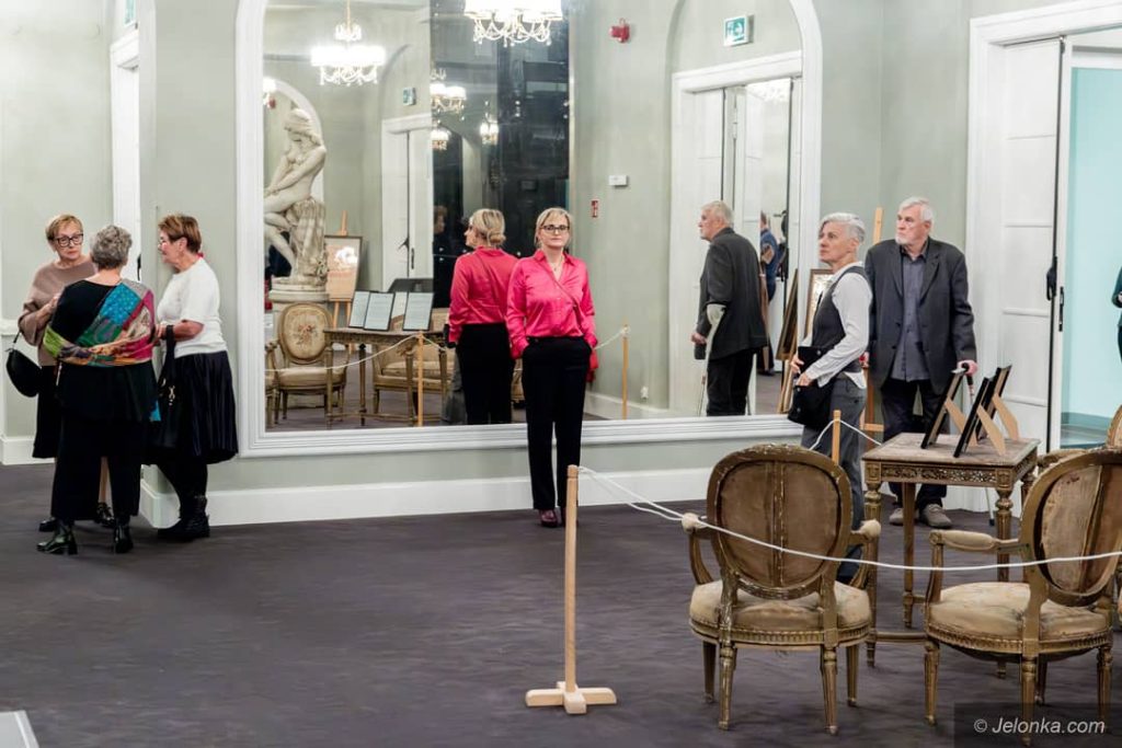 Grupka osób elegancko ubrana stojąca przed wejściem na salę teatralną