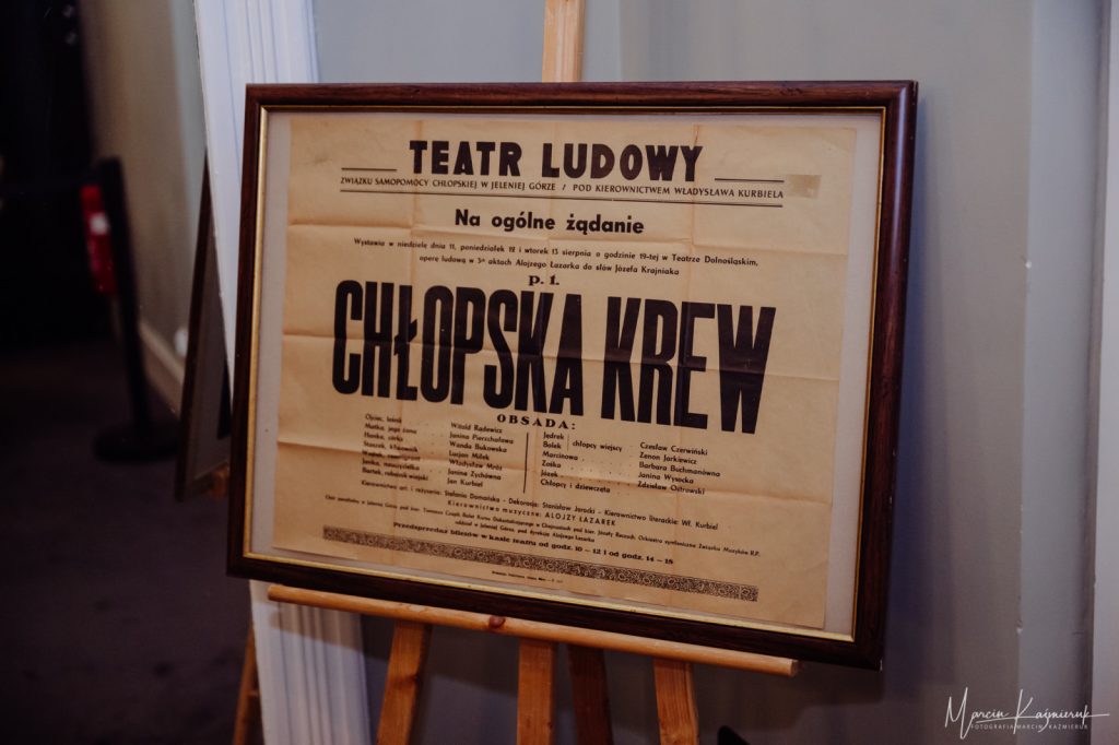 Afisz z teatru ludowego, z napisem chłopska krew, oprawione w ramkę.