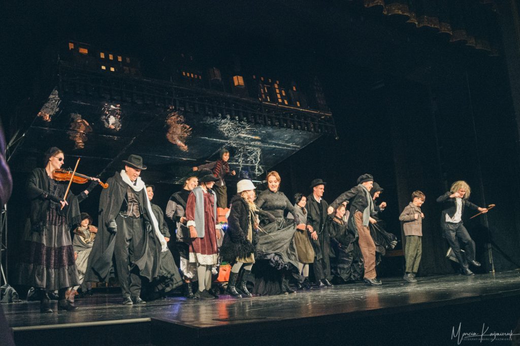 Tłum ludzi na scenie tańczy.