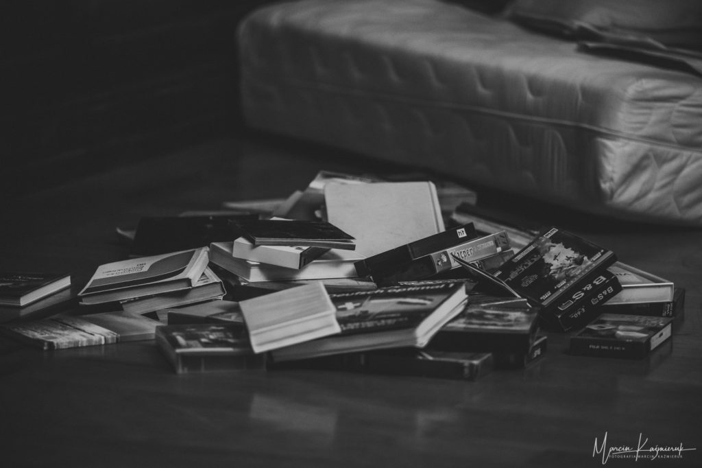 Stos książek leży na podłodze.