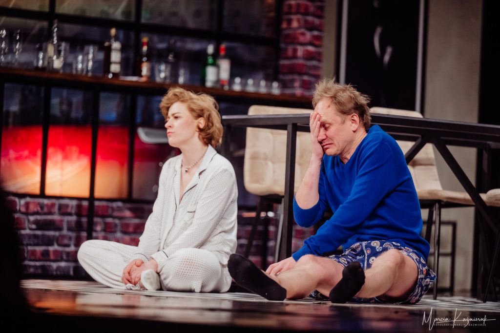 Kobieta i mężczyzna siedzą na ziemi.